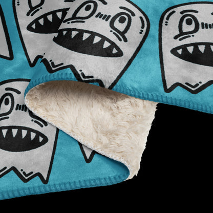 a large sky blue fleece sherpa blanket with grinning goblins