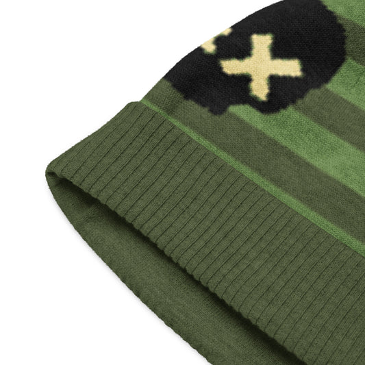 knitted beanie with a black grunge skull with x-eyes on a striped green background