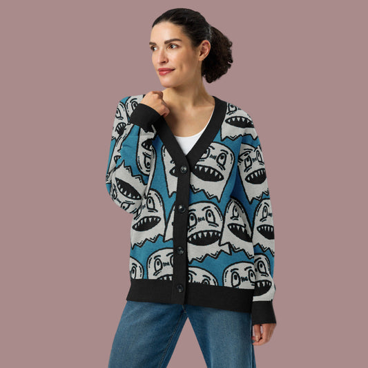woman wearing an electric blue knitted cardigan with large grinning goblin heads in scene and grunge style