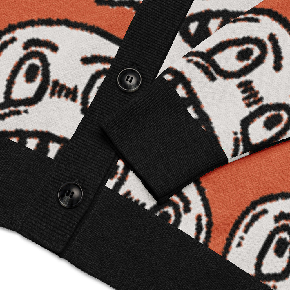 orange knitted cardigan with large grinning goblin heads in scene and grunge style