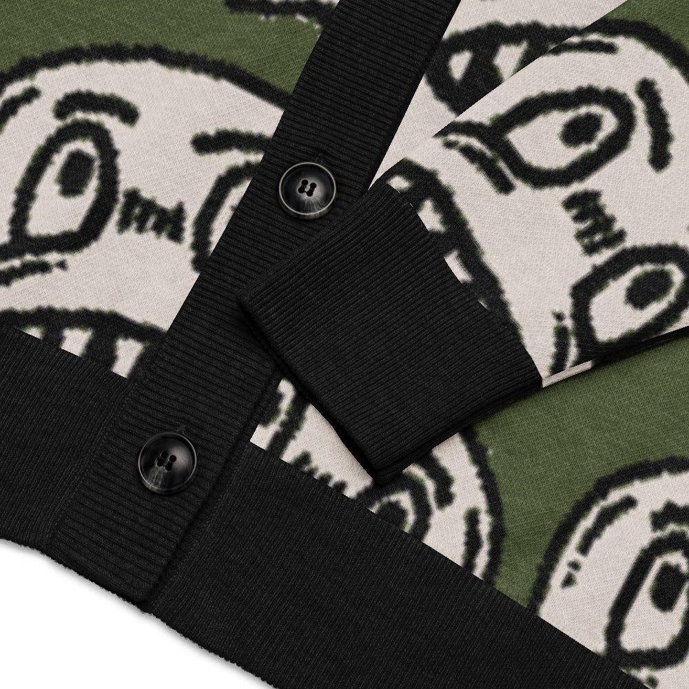 green knitted cardigan with large grinning goblin heads in scene and grunge style