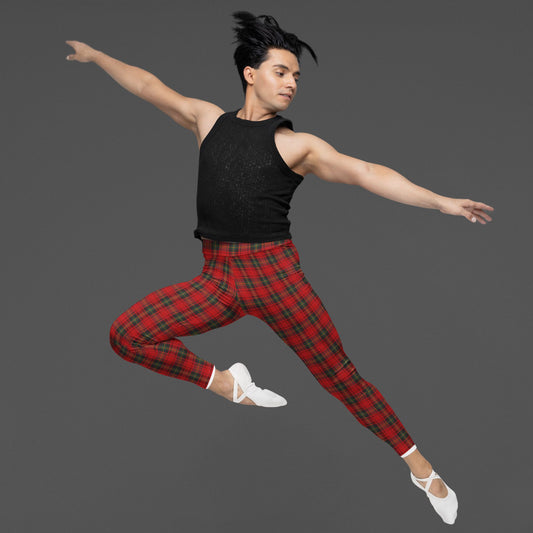 Ballet dancer in black top and red plaid punk pattern leggings jumping against a gray background