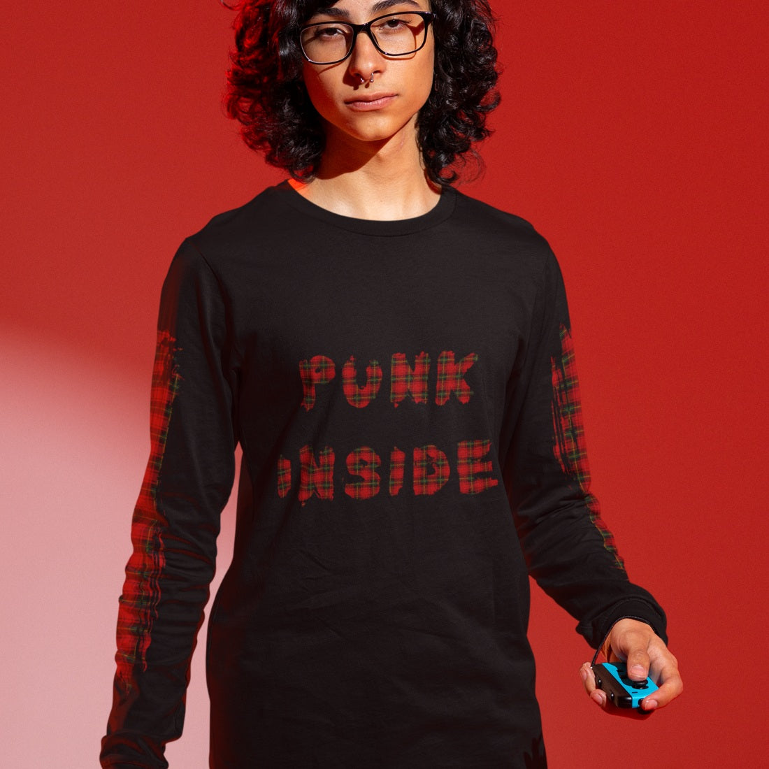 Person wearing a black long-sleeve shirt with 'PUNK INSIDE' text and sleeve plaid prints, on a red background
