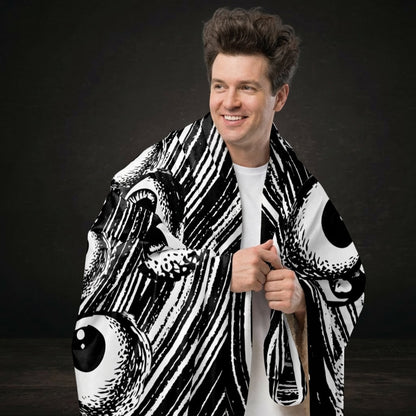 A large sherpa blanket with a black and white drawn vortex and eyeballs floating into it 