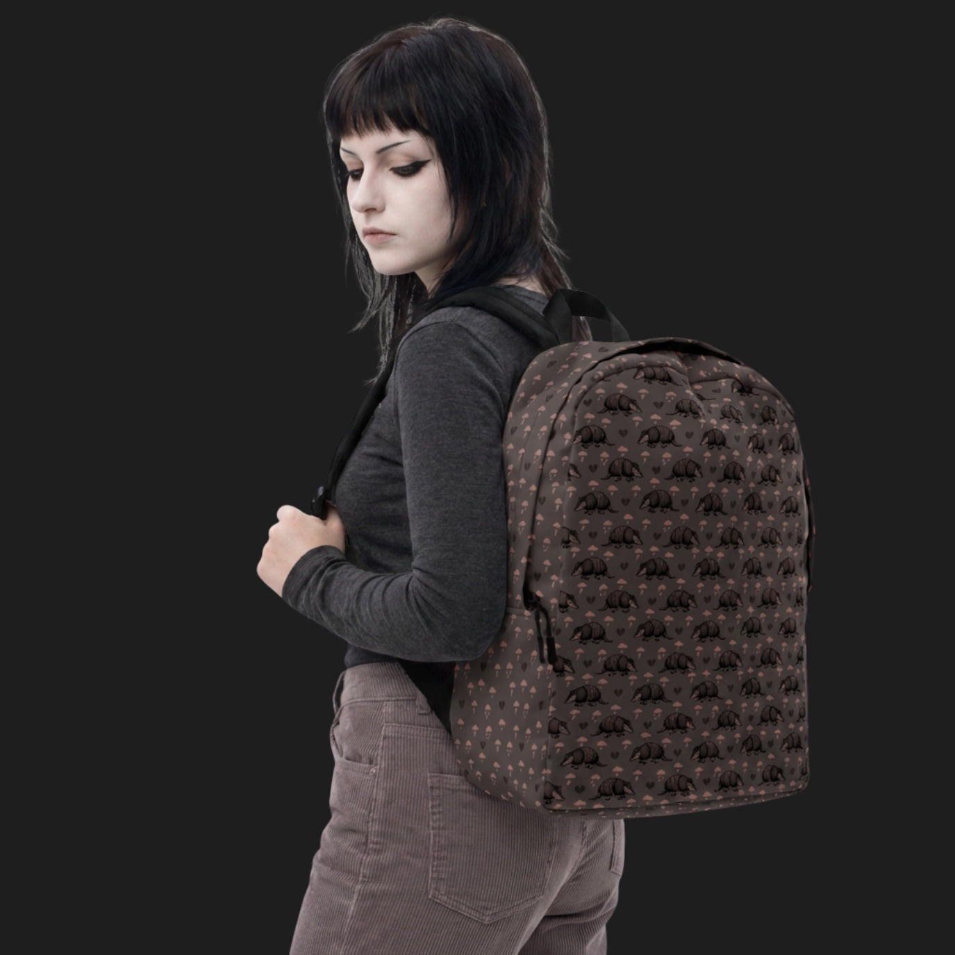 Girl wearing an emo armadillo patterned backpack with broken hearts and storm clouds in dusty pink and grey