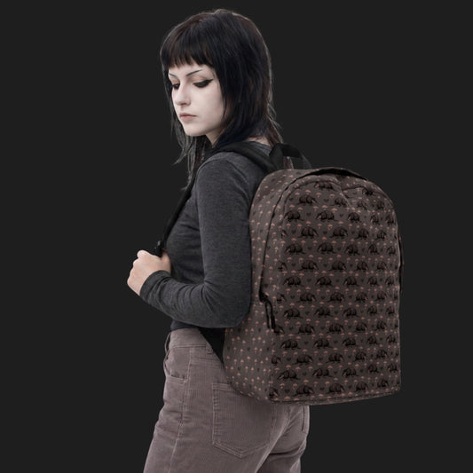 Girl wearing an emo armadillo patterned backpack with broken hearts and storm clouds in dusty pink and grey