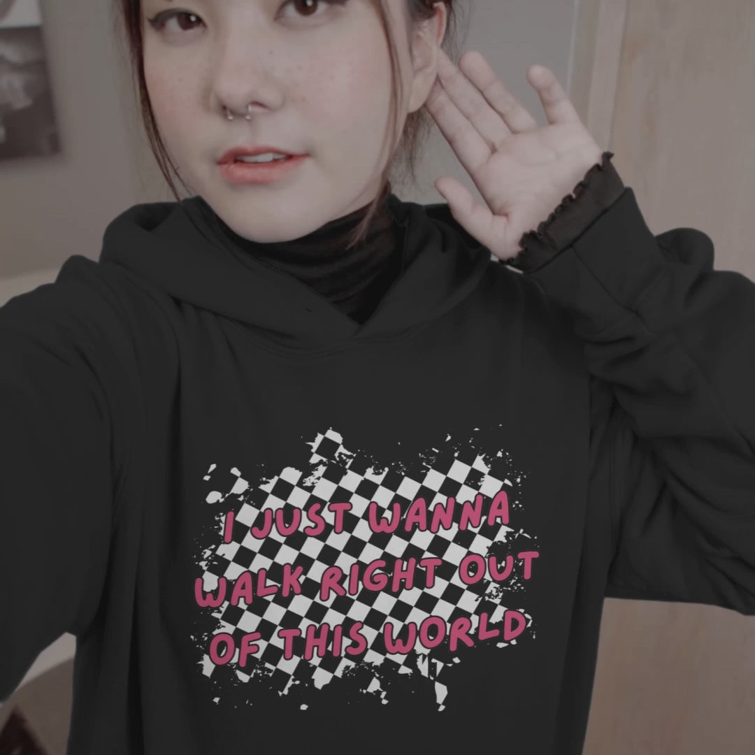 woman wearing a black hoodie with rugged checkers and pink text "i just wanna walk right out of this world" in the front and a checkered road winding away, with text "goodby" on the back