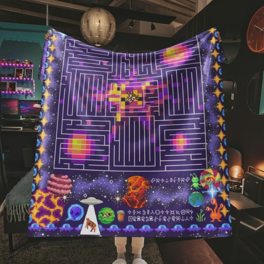 Person in a gamer style room holding a huge sherpa blanket with pixel art puzzles and space theme