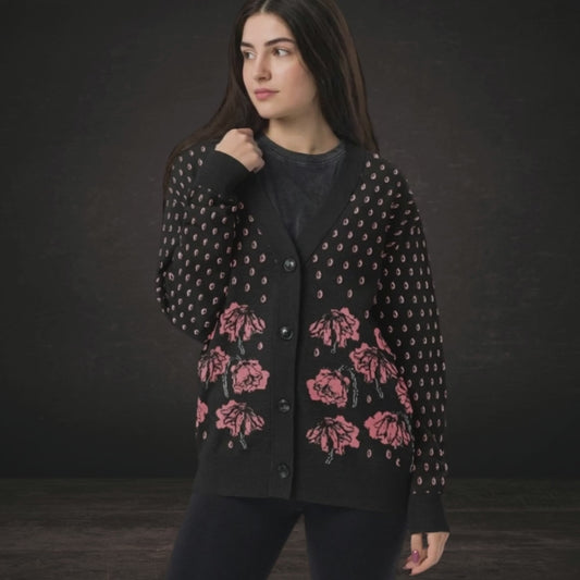 A woman wearing an emotional black knit cardigan with pink crying flowers and teardrops
