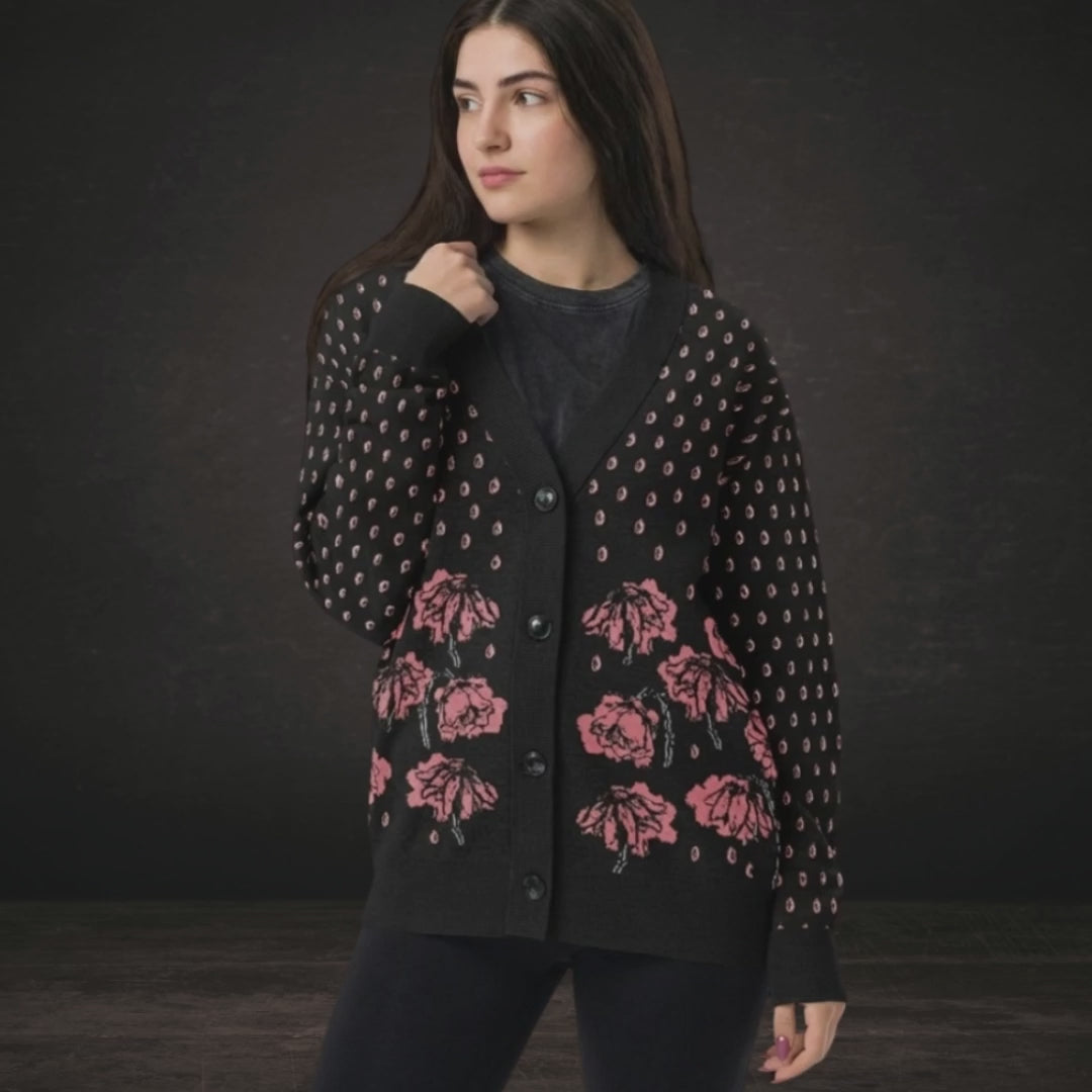 A woman wearing an emotional black knit cardigan with pink crying flowers and teardrops