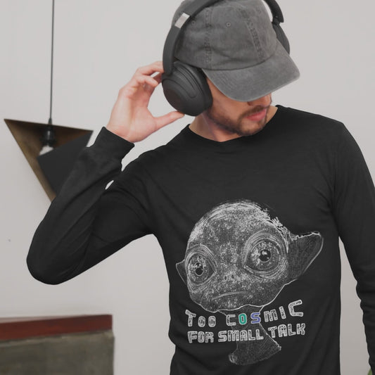 a man with earphones wearing a black long sleeve tee with an alien and thest "too cosmic for small talk"