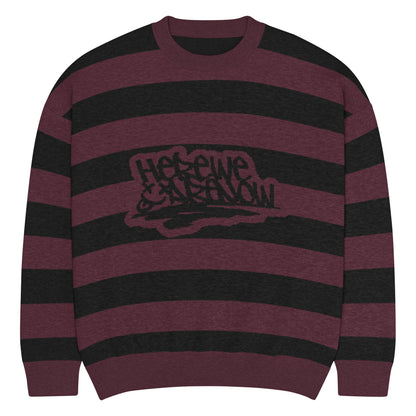 a grunge style dark striped sweater with the text "here we are now"