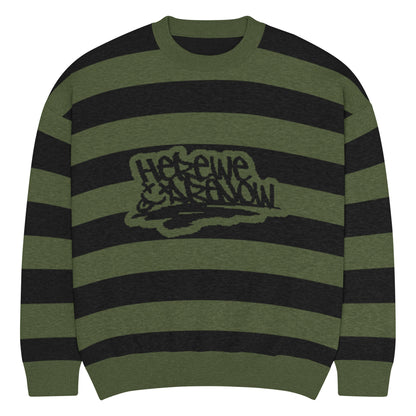 a grunge style dark striped sweater with the text "here we are now"