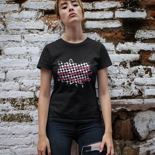 woman by a brick wall wearing ripped jeans and a black alt t-shirt with rugged checkers pattern and text overlay "i just wanna walk right out of this world"