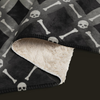 A fleece sherpa blanket with a soft argyle pattern and skulls and bones diagonals