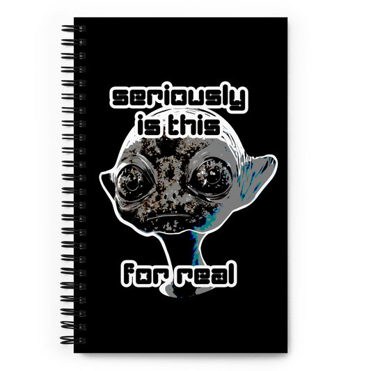 a spiral bound notebook with cover an alien and text "seriously is this for real"