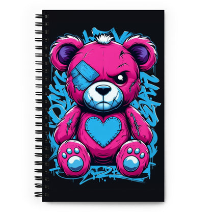 a spiral bound notebook with an angry looking stitched teddy bear on the cover