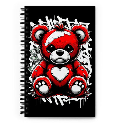 a spiral bound notebook with an angry looking stitched teddy bear on the cover
