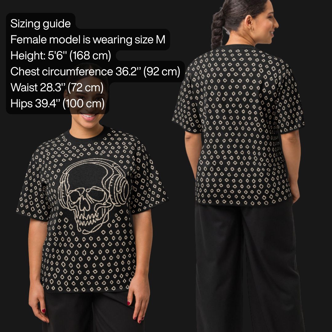 Woman wearing a black short sleeve knit featuring a line art skull with headphones and hand drawn diamonds, with sizing information