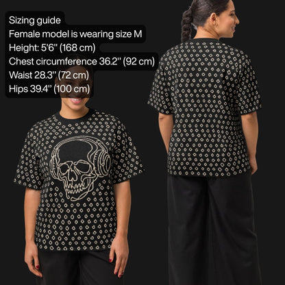 Woman wearing a black short sleeve knit featuring a line art skull with headphones and hand drawn diamonds, with sizing information