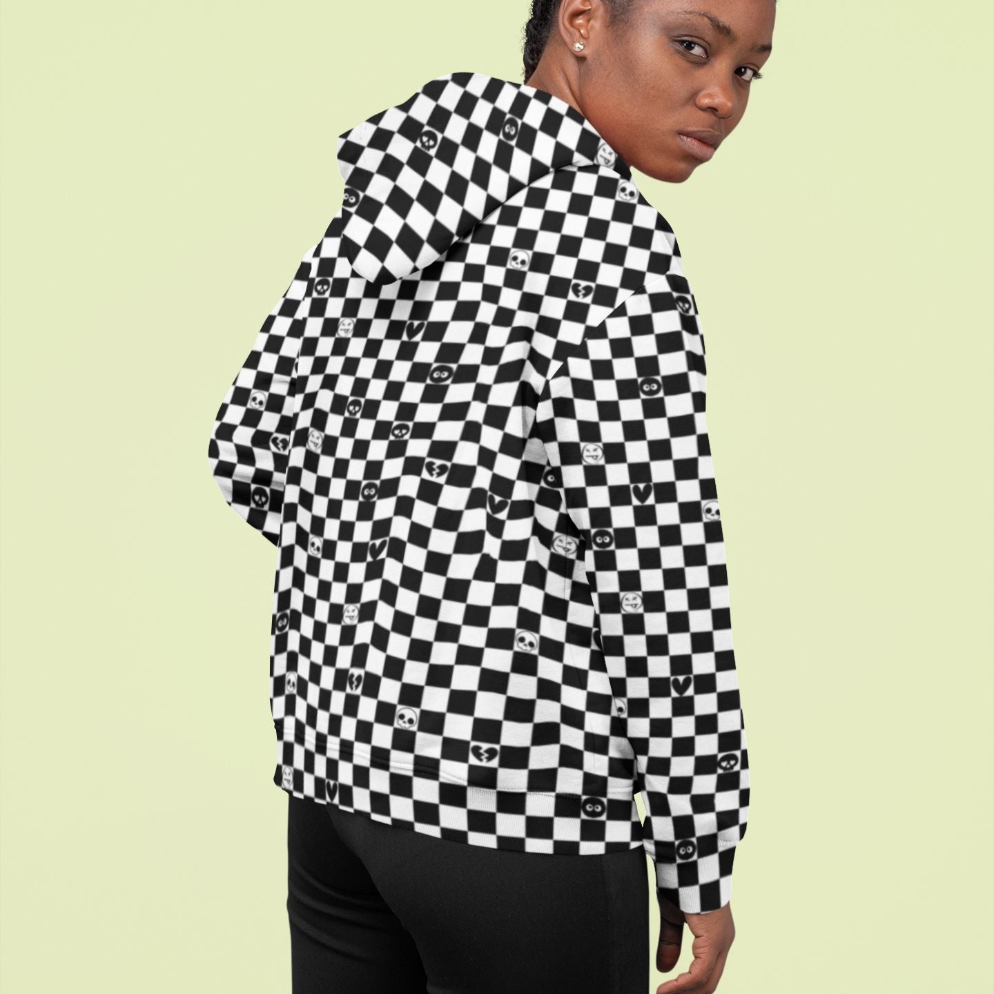 woman wearing a black and white checkered hoodie with emo symbols on some squares