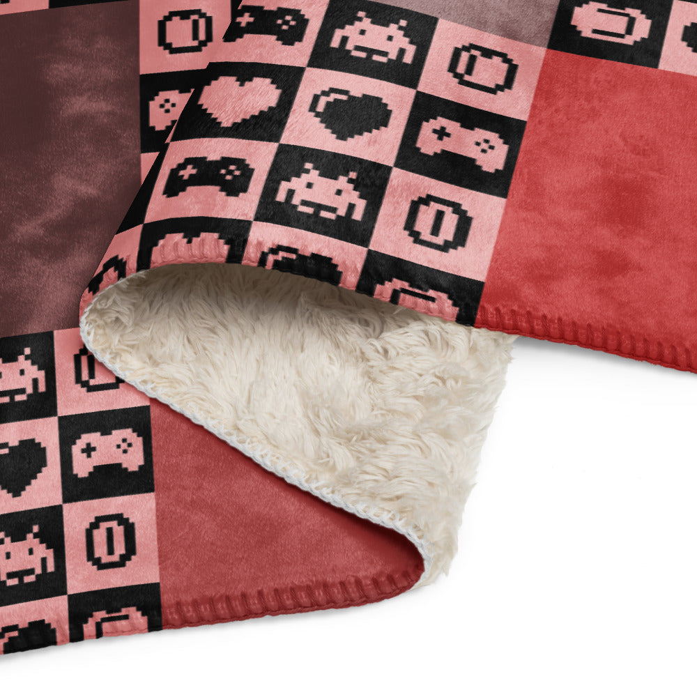 a fleece sherpa blanket with squares and very other square filled with retro pixaleted gaming symbols