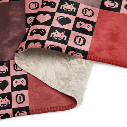 a fleece sherpa blanket with squares and very other square filled with retro pixaleted gaming symbols