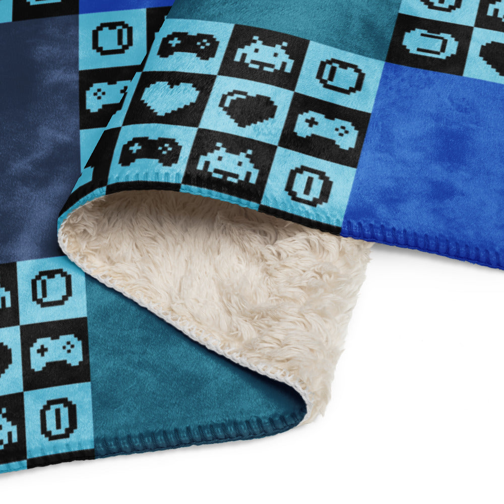 a fleece sherpa blanket with squares and very other square filled with retro pixaleted gaming symbols