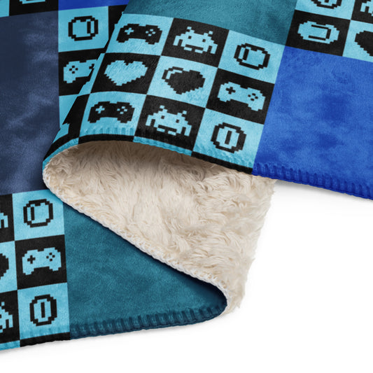 a fleece sherpa blanket with squares and very other square filled with retro pixaleted gaming symbols