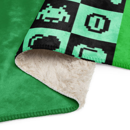 a fleece sherpa blanket with squares and very other square filled with retro pixaleted gaming symbols