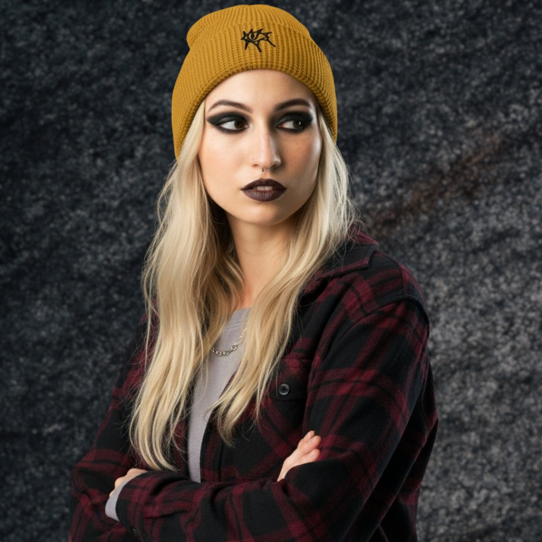 Alt style woman wearing a plaid flannel  and a waffle knit beanie with an emo grunge eye embroidery