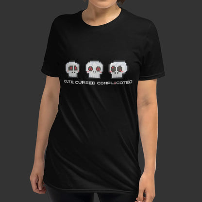Person wearing a t-shirt with pixel art skulls and text "cute cursed complicated"
