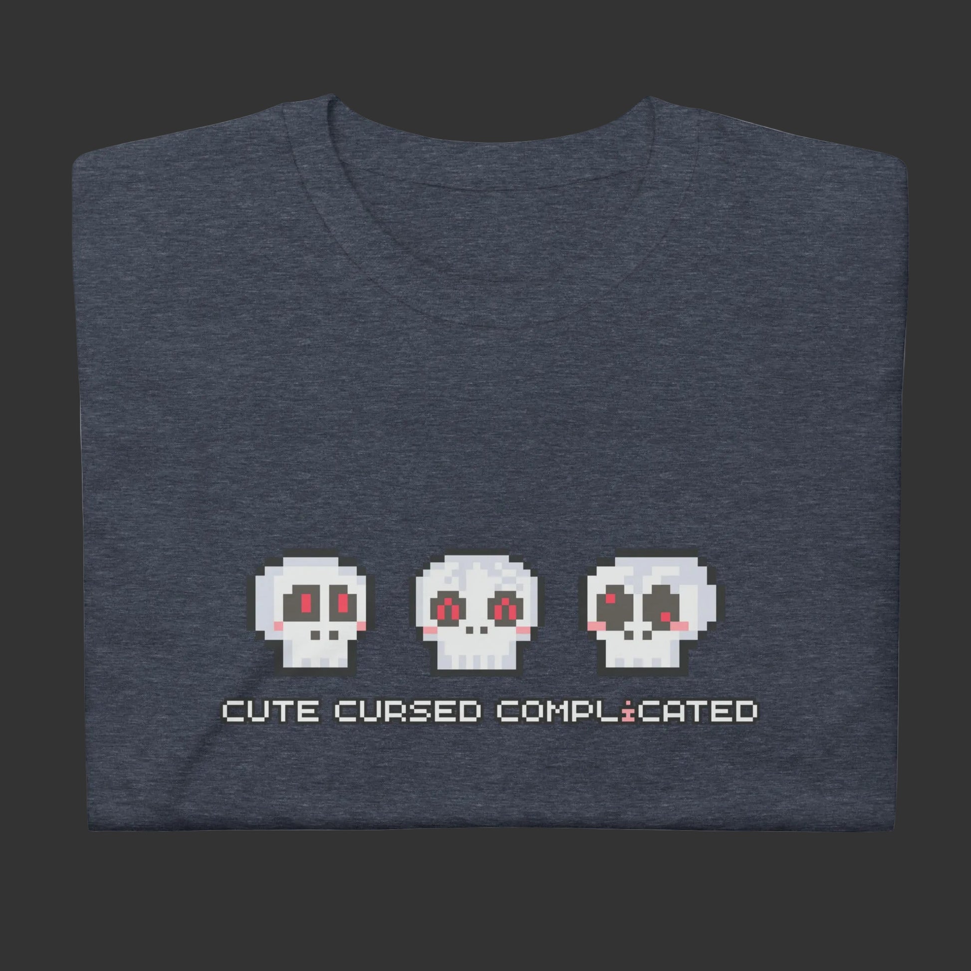 A t-shirt with pixel art skulls and text "cute cursed complicated"