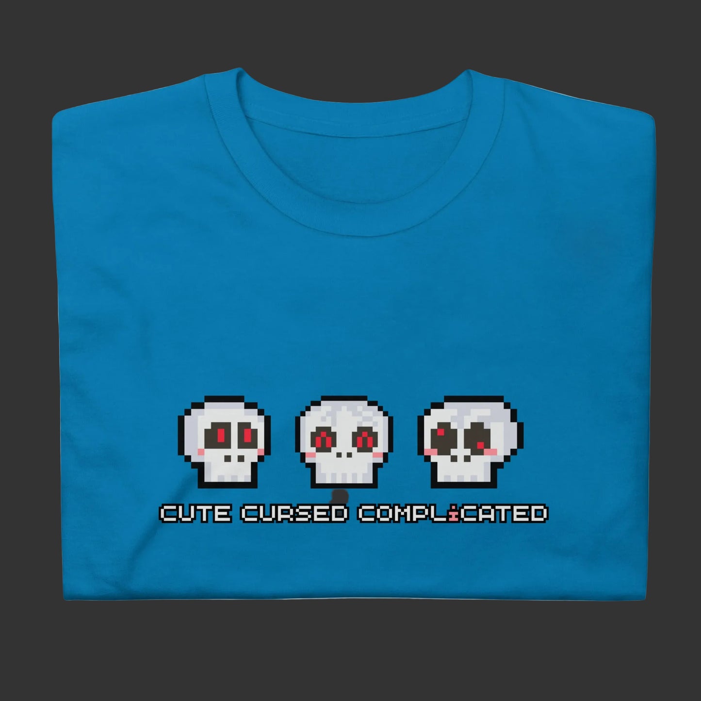 A t-shirt with pixel art skulls and text "cute cursed complicated"