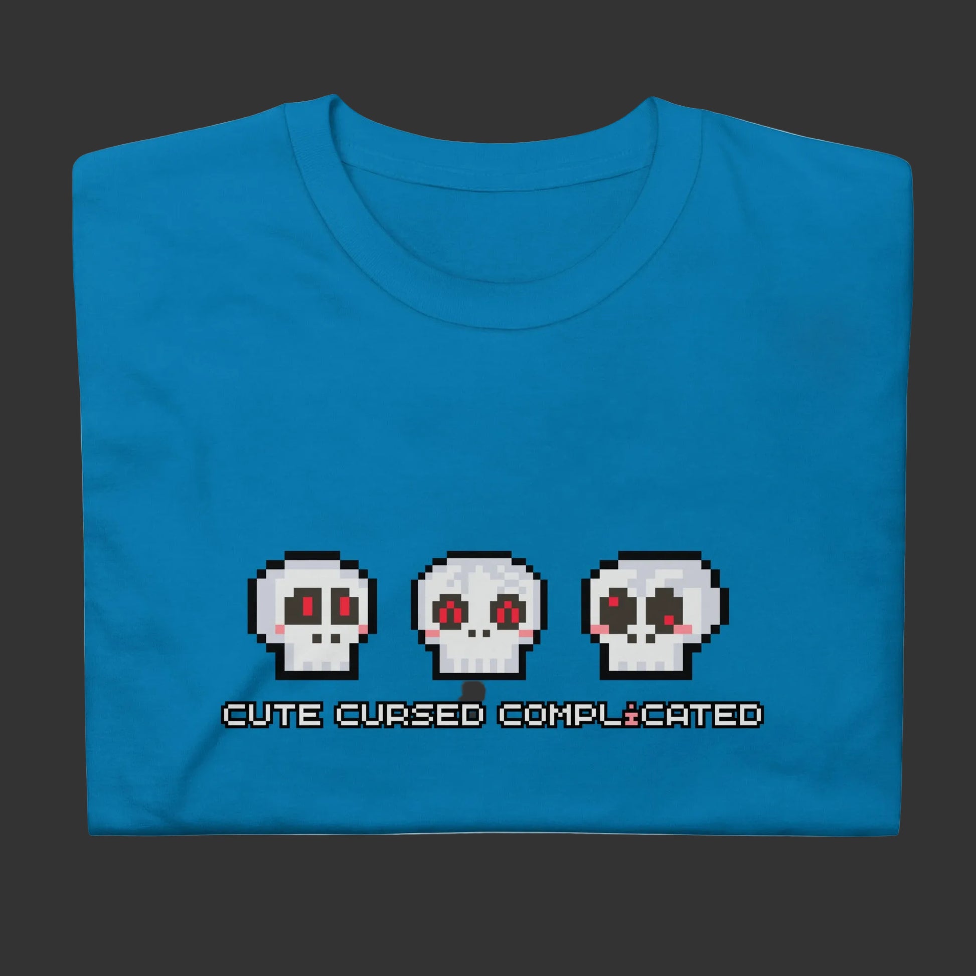 A t-shirt with pixel art skulls and text "cute cursed complicated"