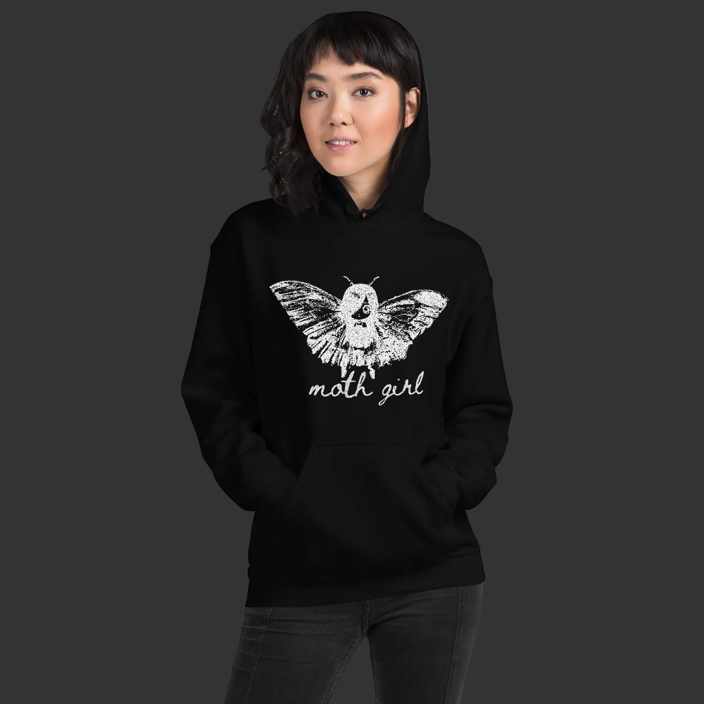 Person wearing a hoodie with a distressed pointillism design of an emo girl with moth wings and the text "moth girl"