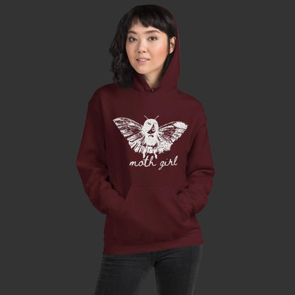 Person wearing a hoodie with a distressed pointillism design of an emo girl with moth wings and the text "moth girl"