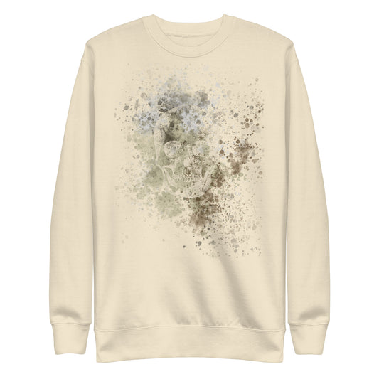 A sweatshirt with subtle skull graphic surrounded and overlaid with paint splatter in camouflage colors on bone white